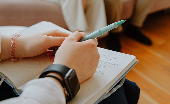 Diagnostik und Ziel Therapeutin notiert Aussagen von Klienten