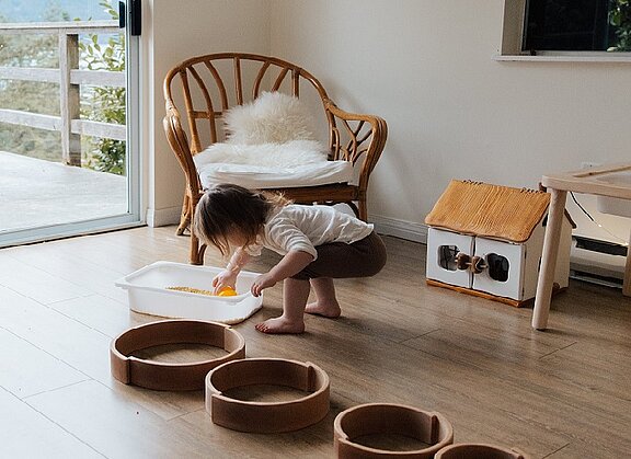 Kind spielt schöpferisch mit Holzschalen  